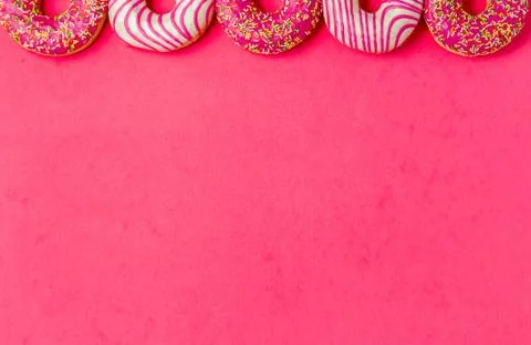 Row of half donut on pimk background. Photo of sweets with copyspace. Top view. Stock Photos