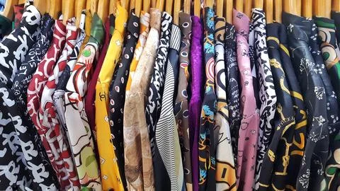 In a row hanging abstract patterned blouse woman on hangers Stock Photos