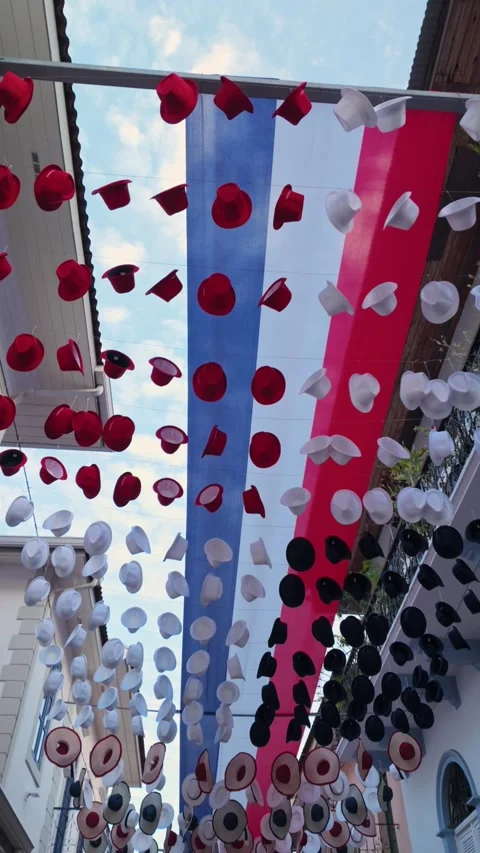 A row of hats hanging from a ceiling, some red, some white, and some blue Stock Footage 326961093