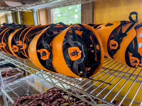 Row of helmets ready for use at a high ropes and climbing course. Stock Photos