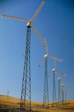 Row of horizontal-axis wind turbines standing on ground Stock Photos