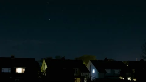 Row of houses sit below trailing stars at night timelapse Stock Footage 142038351