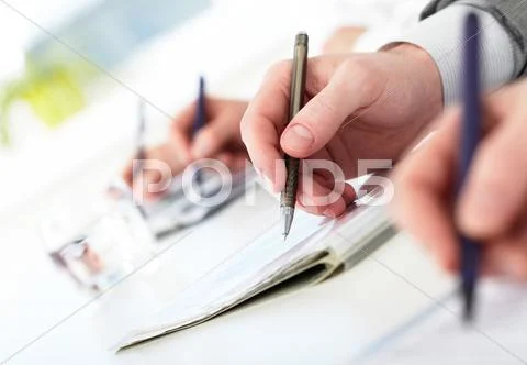 Row of human hands with pens making notes during conference Stock Photos