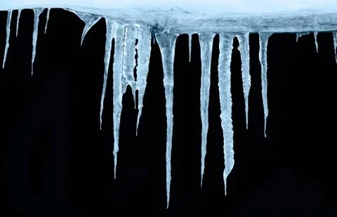 Row of icicles on a black background of isolates Stock-Fotos