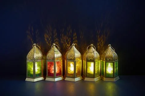 Row of illuminated ramadan lanterns casting shadows Stock Photos