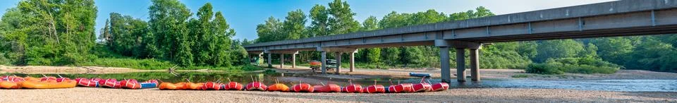 Row of inflatable rafts at the beginning of a float trip on a river. Stock Photos