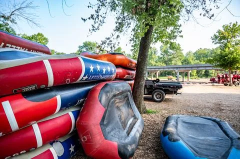 Row of inflatable rafts at the beginning of a float trip on a river. Foto stock