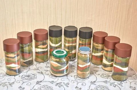 A row of jars filled with a set of bright home-made spices Stock Photos