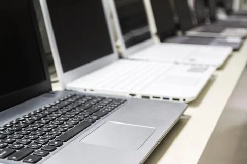 A row of laptops in computer shop. Closeup, selective focus Stock Photos