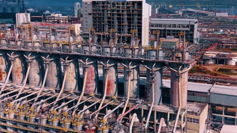 Row of large coke drums at the heavy chemical or oil refinery complex. Drone Stock Footage 340360326