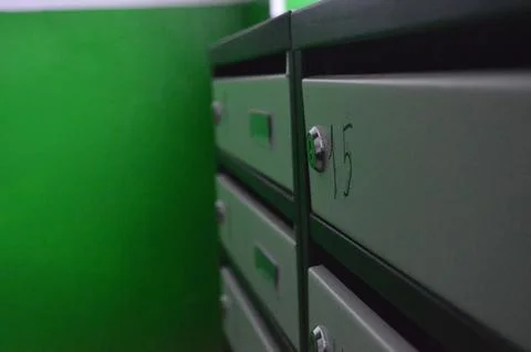 A row of mailboxes with the number 15 on the third one.  Stock Photos