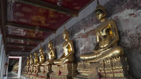 A row of many statues of a gold Buddha sitting in a meditative pose in the 库存影片 289924432