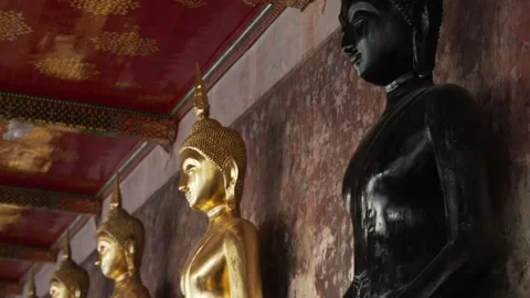 A row of many statues of a gold Buddha and black one among, sitting in a 库存影片 289924457