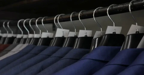 Row of men suit jackets and shirts on hangers. Close up Video stock 75780711