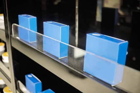 A row of minimalist blue rectangular product boxes neatly arranged on a sle.. 스톡 사진