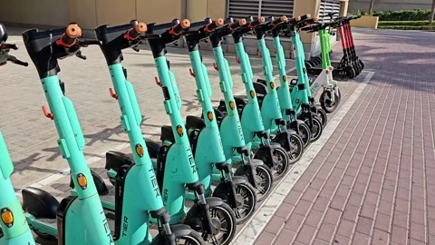 A row of modern, Tier turquoise electric scooters lined up neatly Stock Footage 311767225
