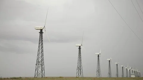 Row of modern wind generators, cloudy grey sky, rainy weather Vidéo 97101213
