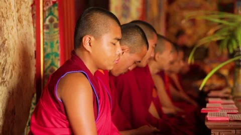 Row of monks sitting in a long hallway Stock Footage 77443920