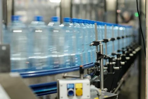 Row of Moving Capped Plastic Bottles on Production Line Stock Photos