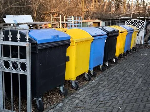 A row of multi-colored plastic containers for sorting waste Stock Photos