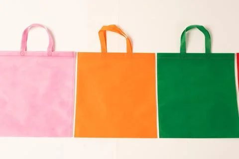 Row of multi colour canvas bags with copy space on white background Stock Illustration