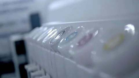 A row of multiple cartridges of different colors from a large industrial printer Vídeos de archivo 340462932