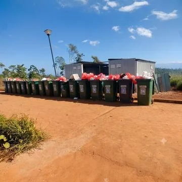 Row of numbered plastic waste bins with garbage bags in an outdoor collection ar Stock Photos