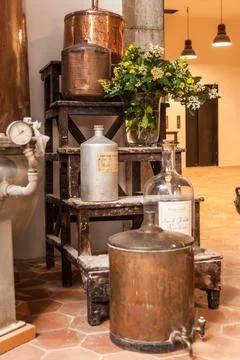 A row of old-fashioned copper containers sit on a wooden platform in museum.. Stock Photos