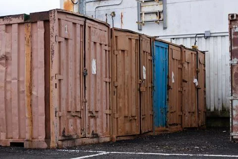 A row of old, rusty, shipping containers 스톡 사진