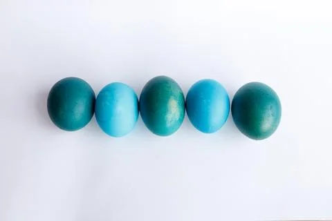 Row of ombre blue Easter eggs isolated on white background Stock Photos