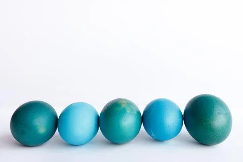 Row of ombre blue Easter eggs isolated on white background Stock Photos