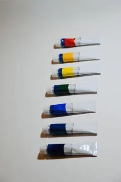 Row of Paint Tubes on White Surface with Copy Space Stock Photos