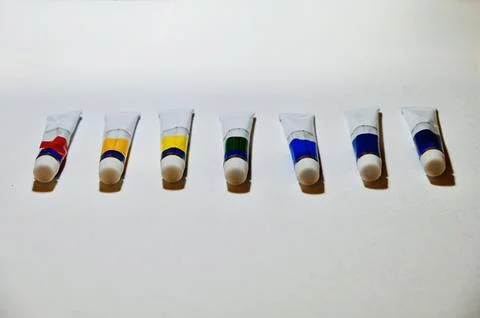 Row of Paint Tubes on White Surface with Copy Space Stock Photos