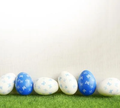Row of painted colored easter eggs on green grass. Stock Photos