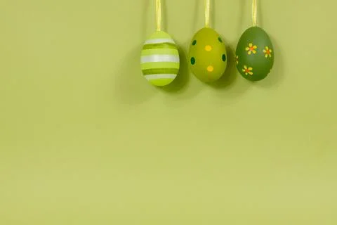 A row of painted multi-colored eggs in a row on a green background. Easter Stock Photos