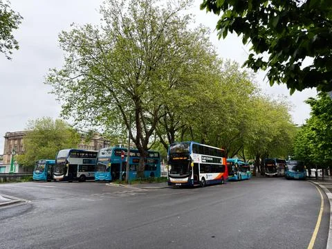 Row of parked double decker buses at a tree lined bus station in Liverpool,.. Foto stock