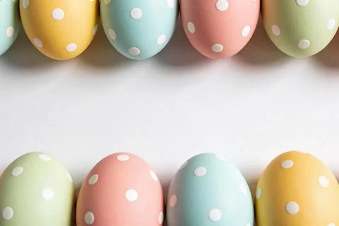 Row of pastel polka dot Easter eggs arranged on a white background for spri.. Stock Photos