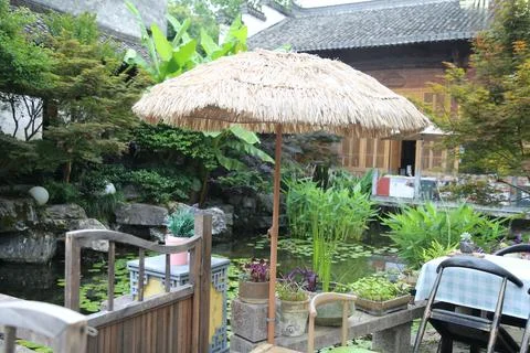Row of patterned outdoor cafe chairs with tables in landscaped courtyard se.. 스톡 사진