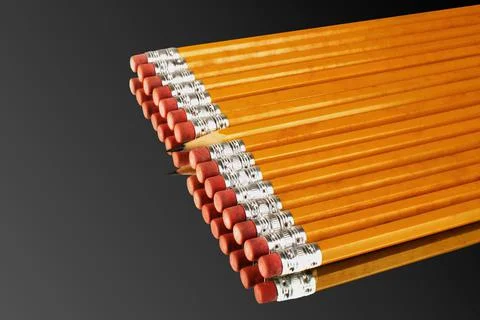 Row of pencils with an exception of a sharp one turning its head against the Foto stock