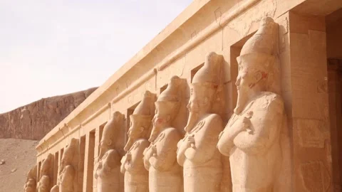 Row of pharoah statues look out over the valley in front of Hatshepsut Stock Footage 255587684