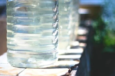 Row of Plastic Bottles Filled with Clean Water From a Public Well Stock Photos