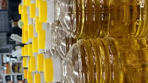 Row of plastic bottles with vegetable oil on a shelf in a supermarket Stock Footage 273577410