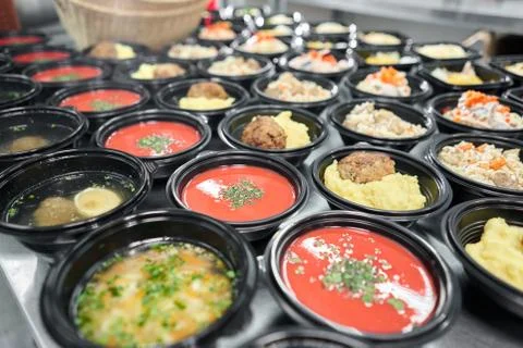 Row of plastic disposable lunch box with healthy natural food. Soups, cream soup Stock Photos