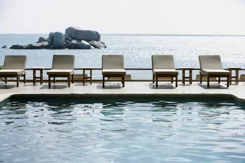 Row of poolside lounge chairs Stock Photos