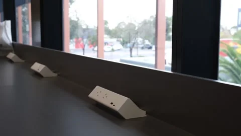 Row of power outlets installed along a desk in a modern library in Australia Stock-Footage 336034828