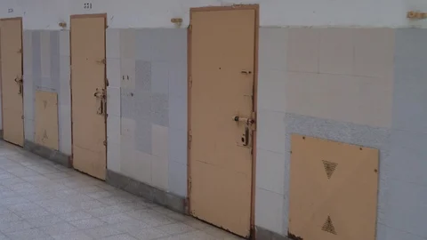 Row of prison cell doors. the camera moves along metal doors of the prison cells Stock Footage 120146016