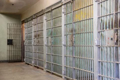 A row of prison cells with bars on the windows Stock Photos