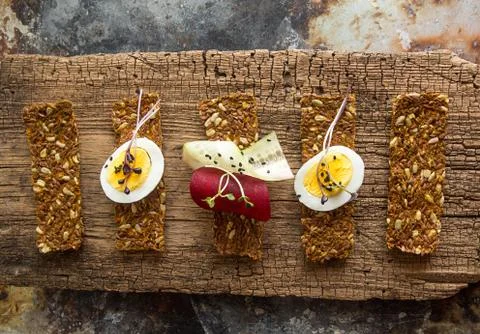 Row of raw bread with sunflower seeds, carrots, sesame, flax seed and other v Stock Photos