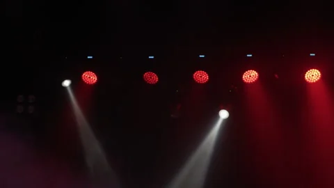 Row of red and white stage lights over dark concert venue Stock Footage 336285591