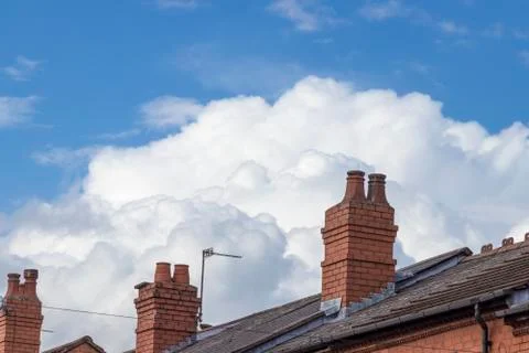 Row of red brick chimneys with clouds and blue sky background Stock Photos